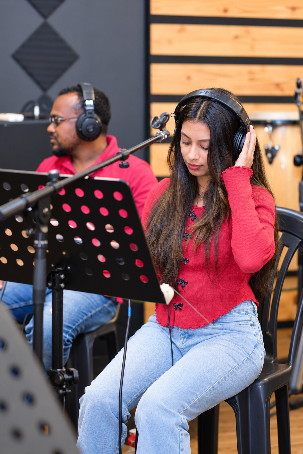 Kawya Erandi in the studio wearing headphones and a red top