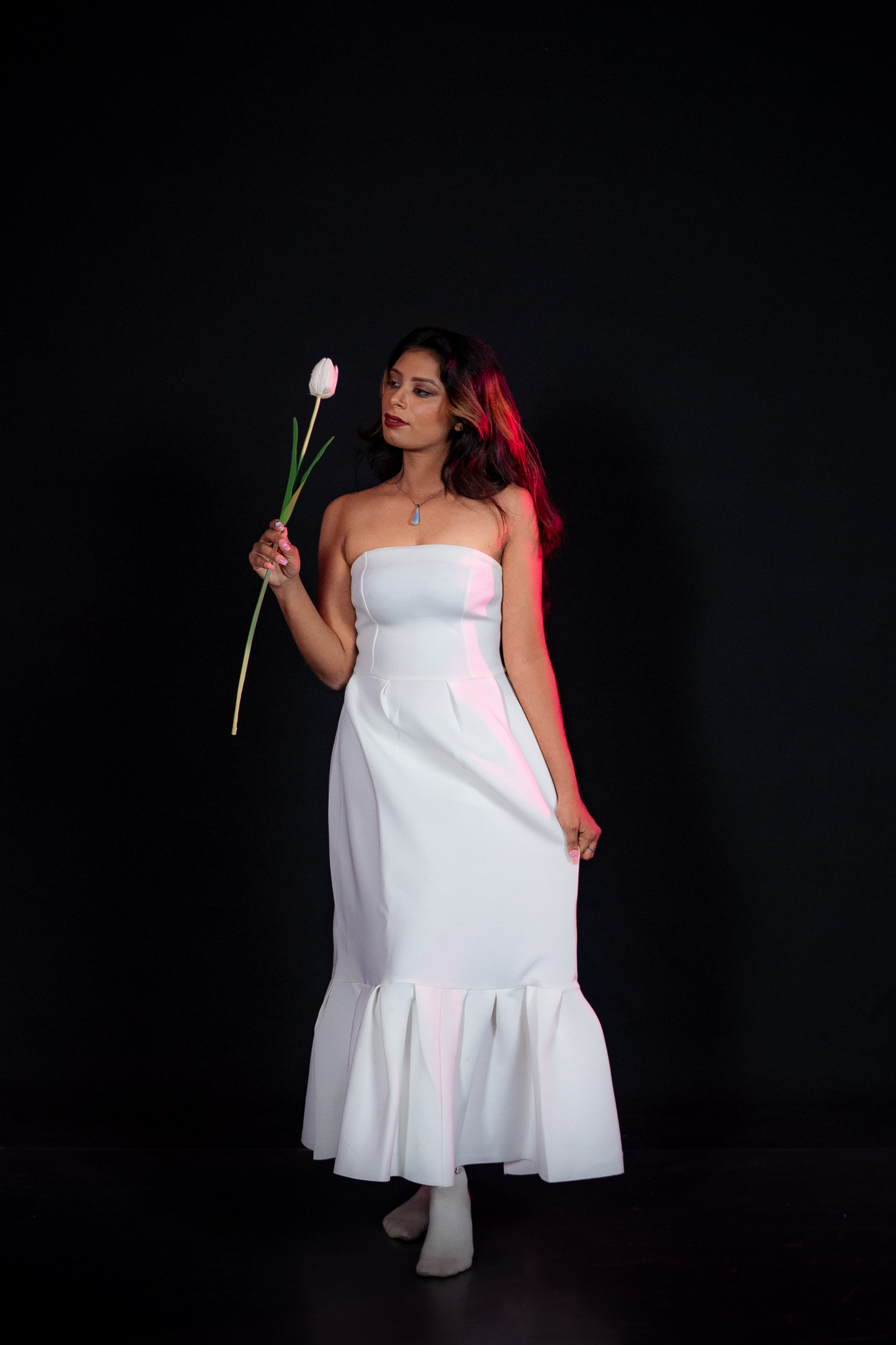 Kawya Erandi — full length in white gown holding a tulip